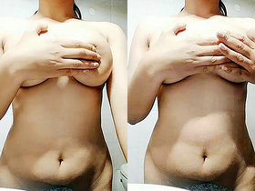 An Indian woman indulges in self-pleasure by fondling her breasts in the bathroom
